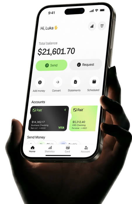 A hand holding a phone with the Ralt app open: a total balance of $21,601.70, Send and Request buttons, and Business and USD checking accounts.